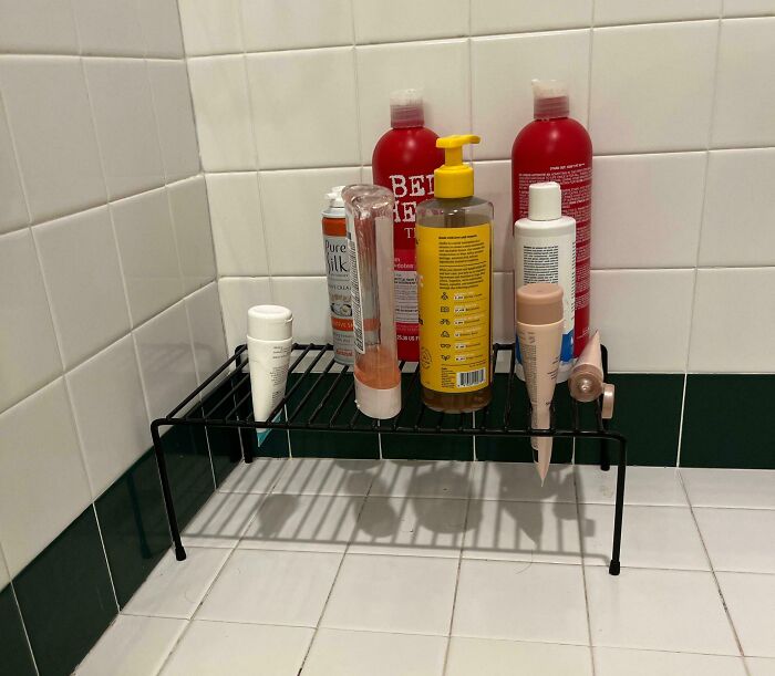 Bathroom shelf life hack organizing shower products in a corner to save space and keep items easily accessible.