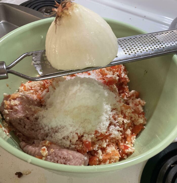 Bowl with ground meat, grated onion and cheese being prepared using a grater, showcasing genius life hacks for cooking.