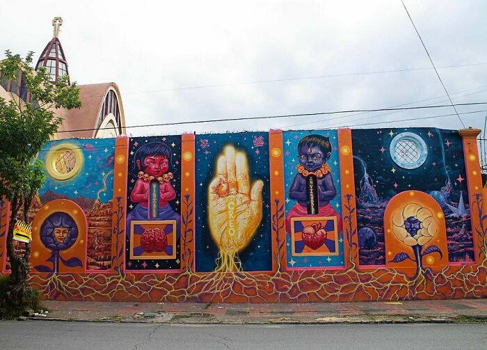 Vibrant Colombian artist SakoAsko mural blending fantasy and reality with surreal characters and symbolic imagery on urban wall.