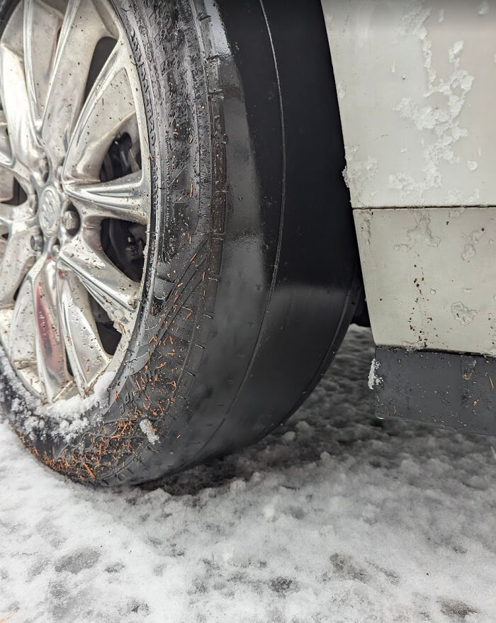 Close-up of a car tire totally worn out on a snowy ground, showing a rare mechanic sight to make others believe.