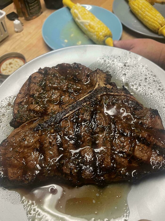 Juicy grilled steak on a plate with corn on the cob in the background, highlighting restaurant workers' order challenges.
