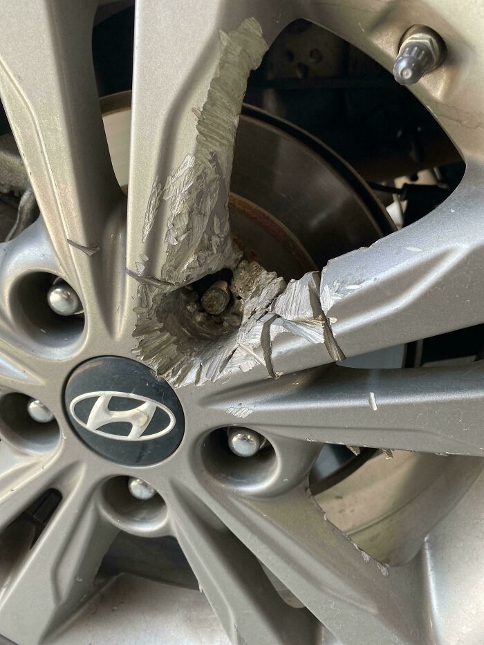 Close-up of a car wheel with severe damage showing the need for mechanic inspection and repair evidence.