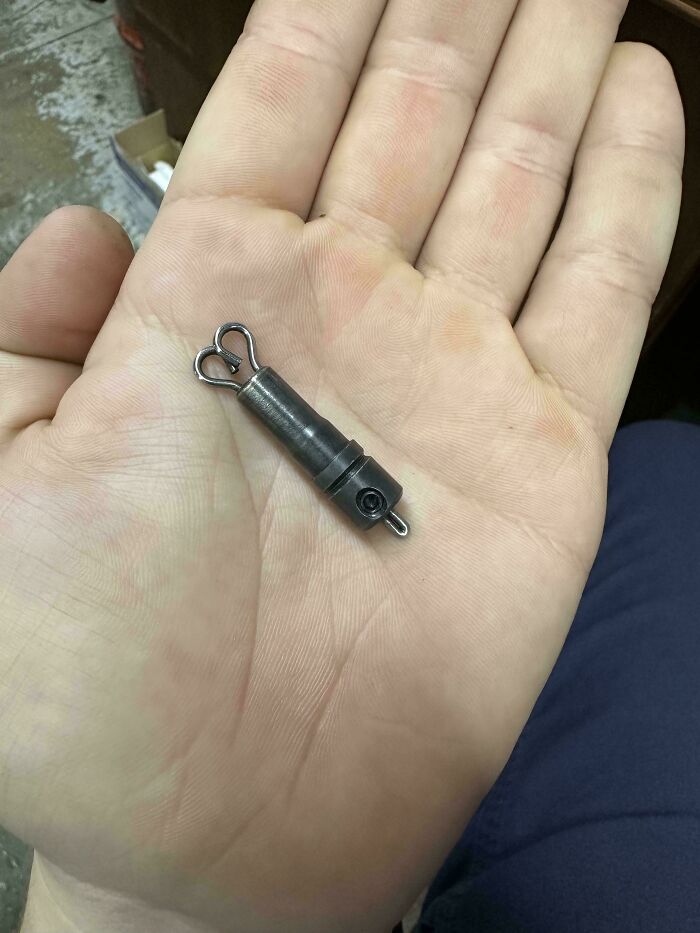 Small metal car part held in a mechanic’s hand, showing a detailed close-up for car mechanics to document.