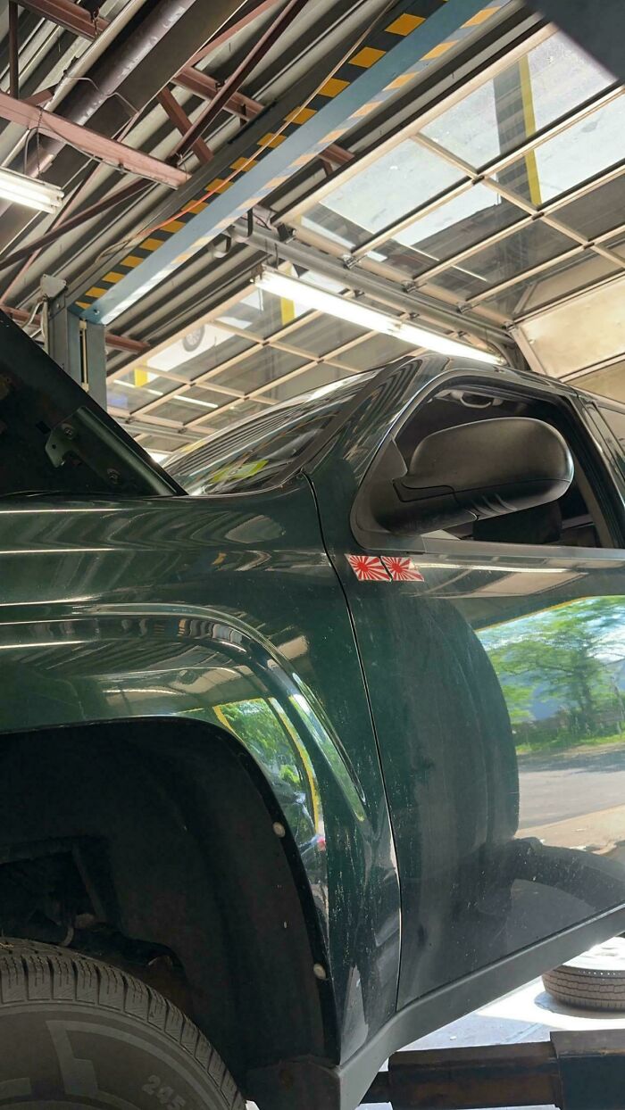 Dark green pickup truck with open hood inside a mechanic shop, illustrating customers leaving mechanics speechless at auto shops.