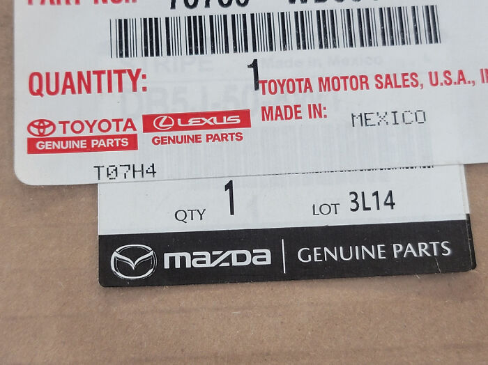 Close-up of car mechanic genuine parts labels from Toyota, Lexus, and Mazda showing part quantities and origins.