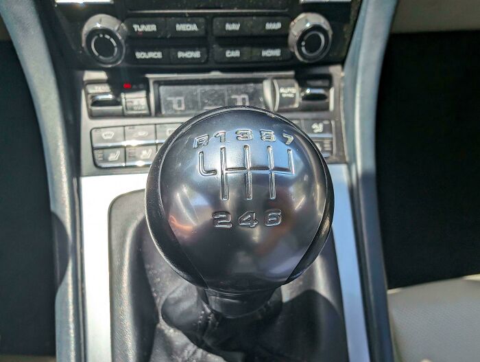 Close-up of a car mechanic’s photo showing a manual gear shift k**b with an unusual 7-speed pattern.