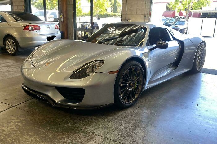 Silver sports car inside a garage with a focus on car mechanics capturing unusual vehicle details.
