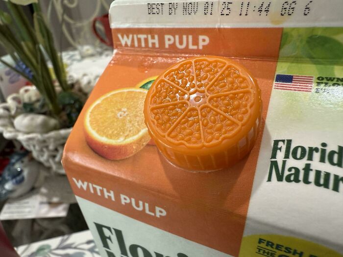 Orange juice carton with a cap designed like an orange slice, showcasing smart and cool product design by designers.