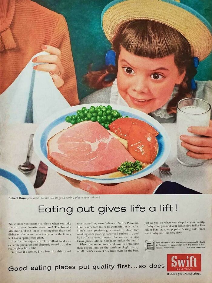 Vintage advertisement showing a girl excitedly holding a glass of milk with a plate of baked ham and vegetables.