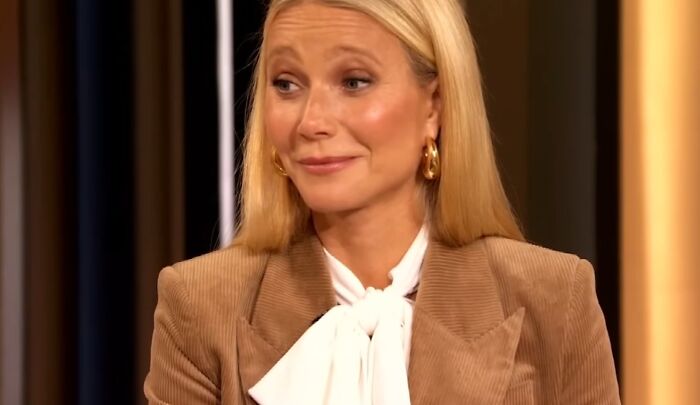 Blonde woman in brown blazer and white blouse showing entitled attitude while talking about work and life.