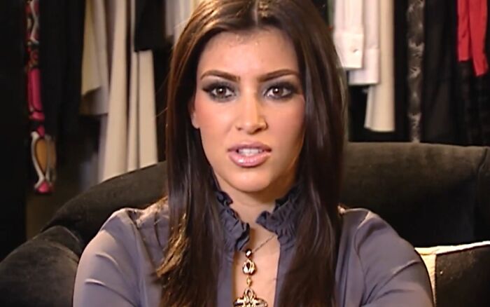 Young woman with dark hair and smoky eye makeup speaking about work and life, showing celebrity entitlement in an interview setting.