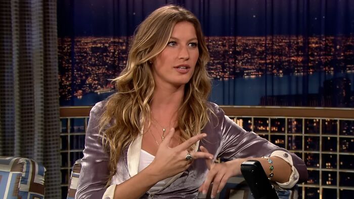 A celebrity woman with long blonde hair speaking about work and life in an indoor interview setting at night.