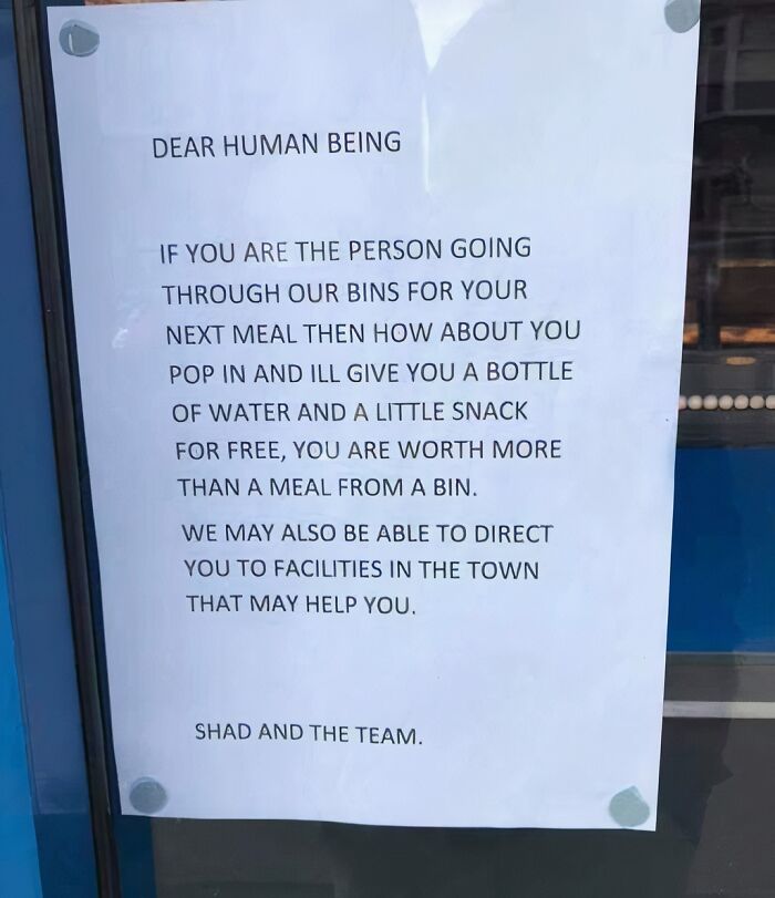 Handwritten heartwarming sign offering free water and snacks to people searching bins, spreading kindness and hope.
