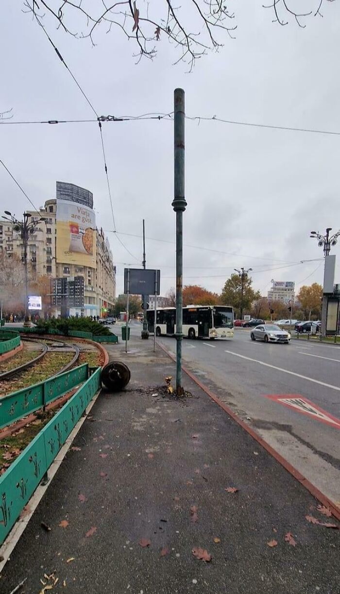 Street scene showing a fallen trash can and poorly placed pole causing a perfectly preventable fail in urban design.