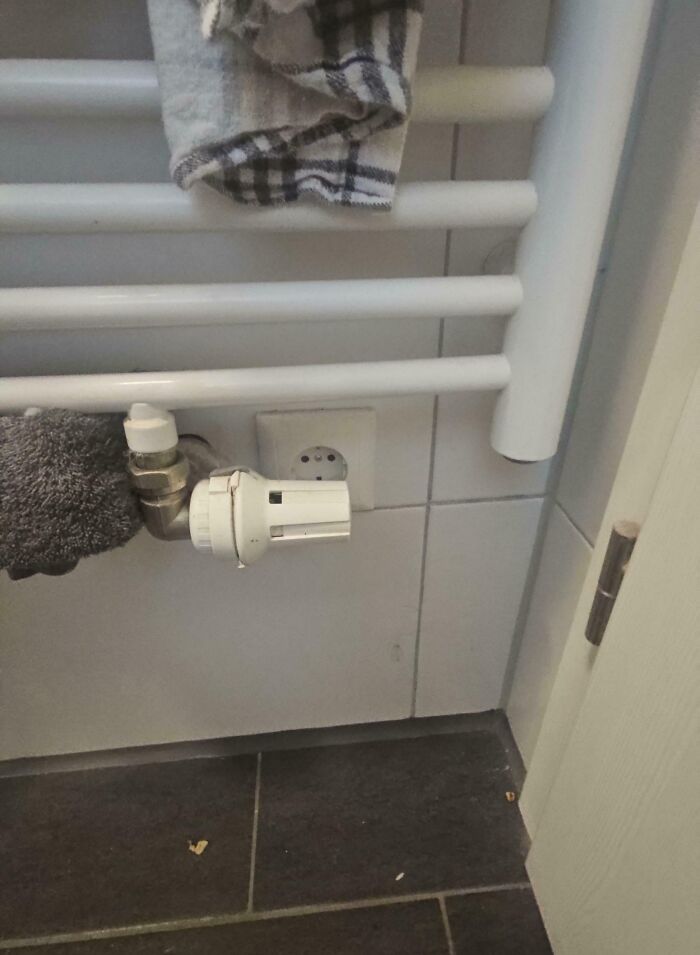 Radiator valve installed directly in front of a wall power outlet displaying a perfectly preventable fail.
