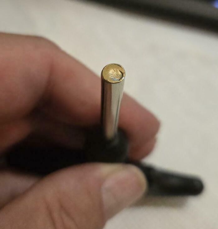 Close-up of a damaged screwdriver tip held by a hand, illustrating a perfectly preventable fail.