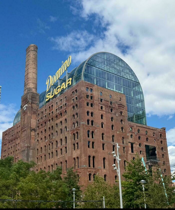 The iconic Domino Sugar Refinery building, a blend of old brick industrial architecture and modern glass.