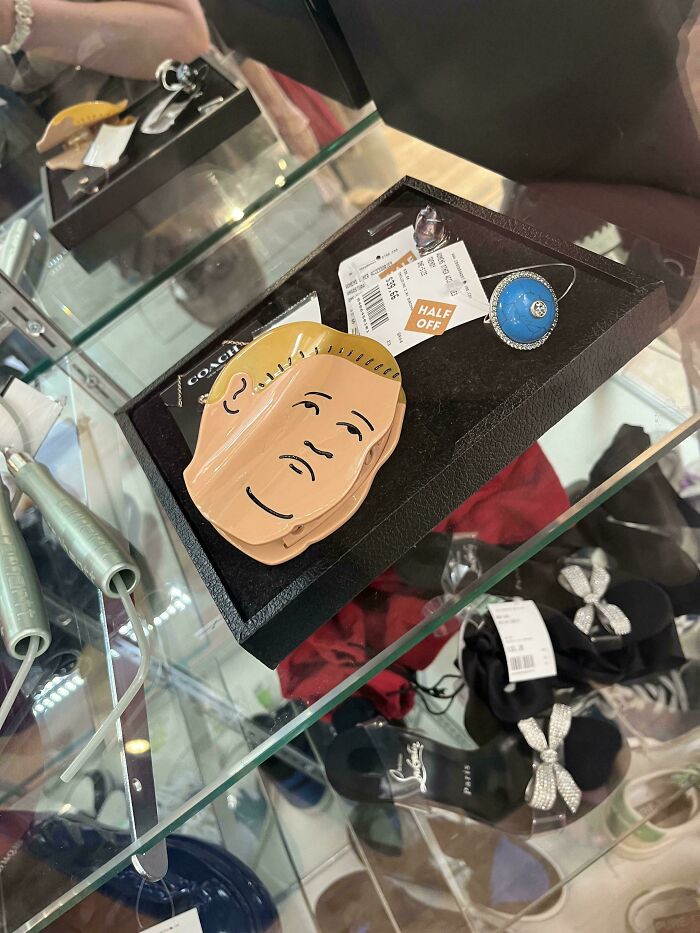 Thrift store finds including a unique mask and jewelry displayed in a glass case with discount tags visible.