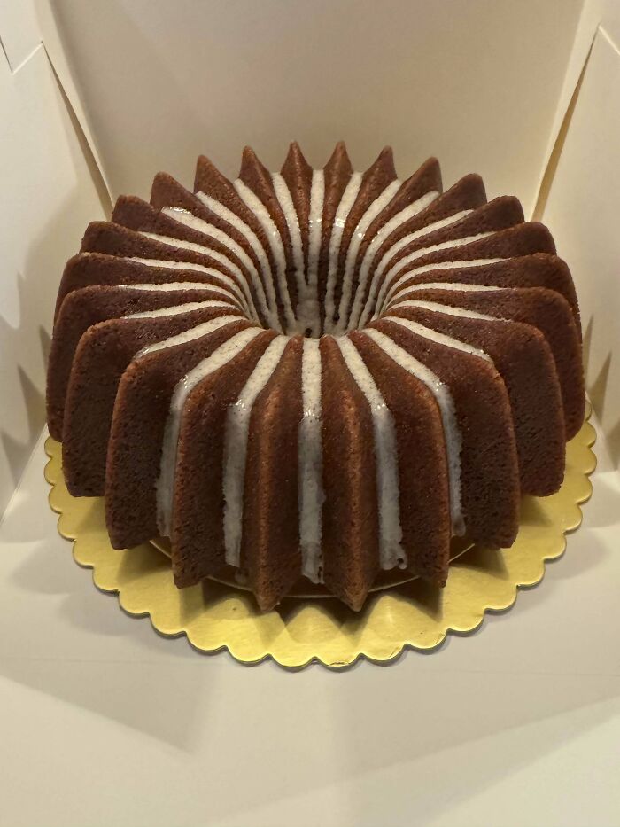 Bundt cake with white glaze drizzled on top, showcasing gorgeous baked goods with intricate design and texture.