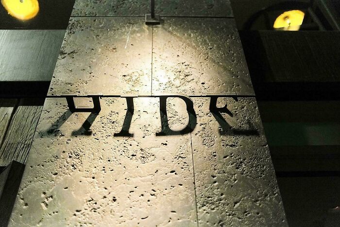 Modern building sign with clever shadow design spelling hide, showcasing smart and cool designer creativity.