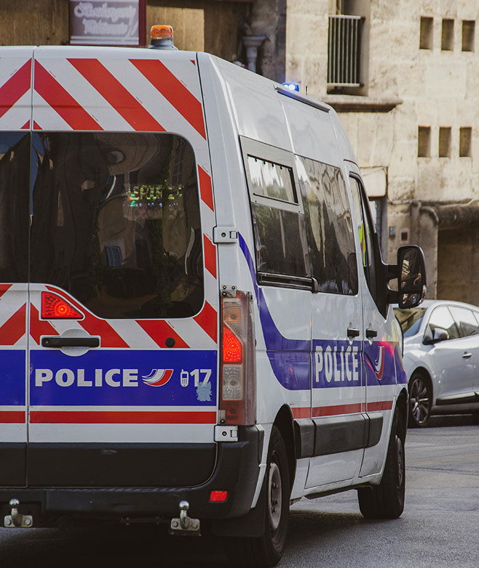 Police van parked on a city street, related to arrest and deportation incident involving disrespect at Tomb of Unknown Soldier.