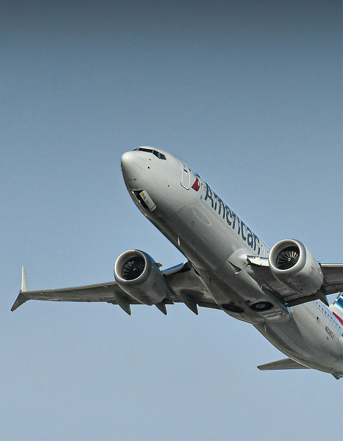 Commercial airplane in flight against clear sky, relevant to man caught vaping on plane incident and flight attendant dispute.