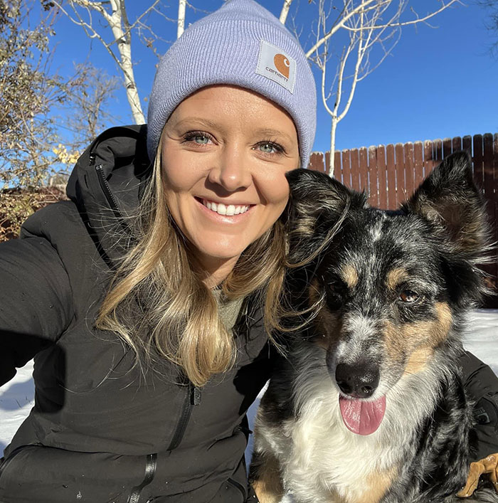 Woman in a beanie smiling with a dog outdoors, related to Kelly Clarkson's ex-assistant and Brandon Blackstock obituary mention.
