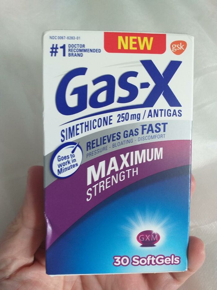 Hand holding Gas-X maximum strength softgels box, highlighting discreet packaging and self-checkout aisle convenience.