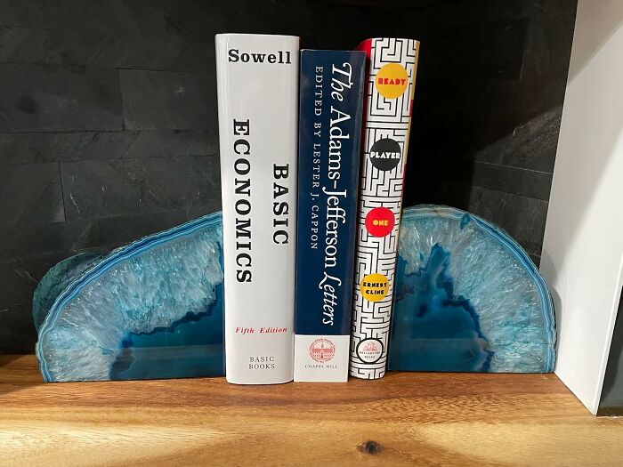 Blue agate bookends holding books on a wooden shelf, showcasing sneakily useful decor items that earn their keep.