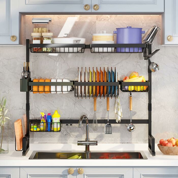 Compact kitchen organizer with hanging storage racks, dishes, and utensils, perfect for tiny apartment furniture solutions.