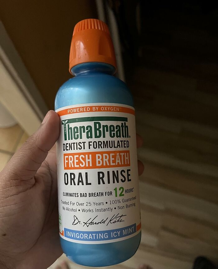 Hand holding TheraBreath fresh breath oral rinse bottle, an example of discreet packaging at self-checkout aisles.