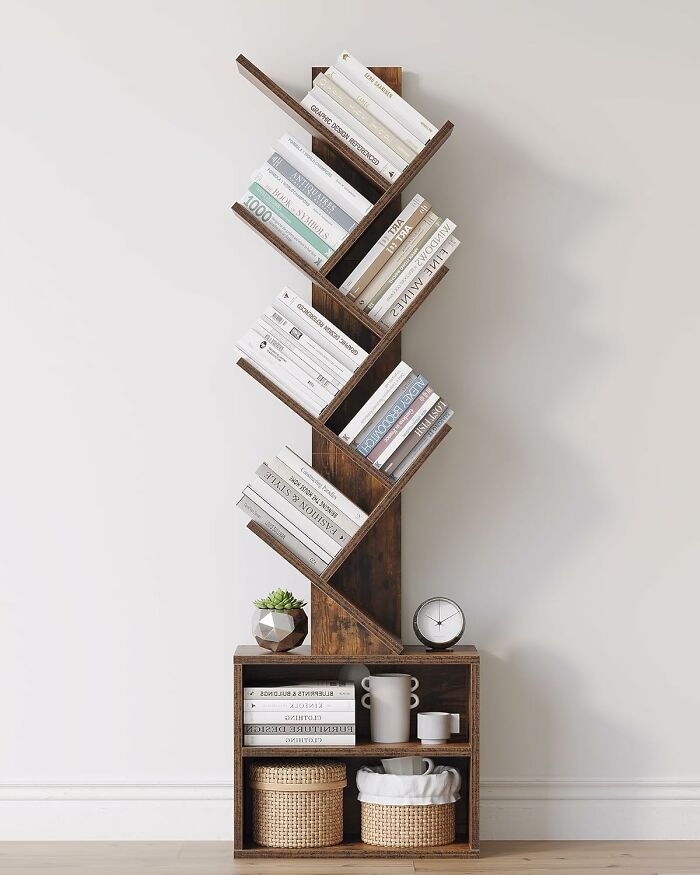 Unique tiny apartment furniture bookshelf with angled shelves holding books, a clock, and decorative items in minimalist space.