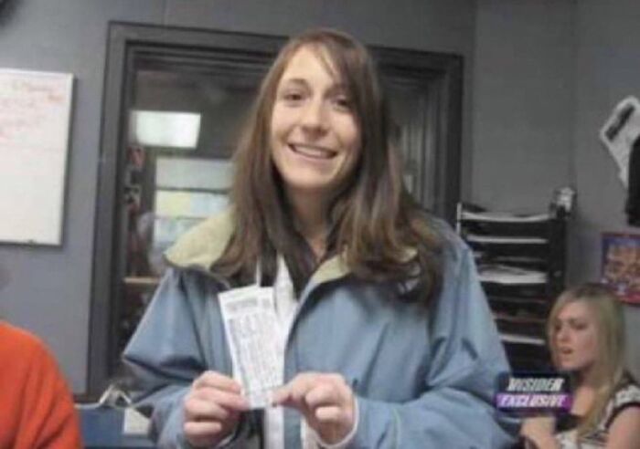 Young woman smiling indoors holding papers, part of unsettling images from the Morbid Knowledge online group collection