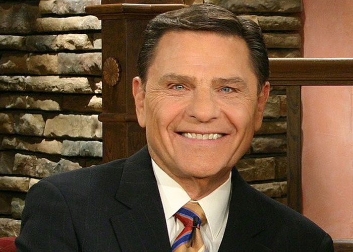 Man in a suit smiling in front of a stone wall, representing jobs related to a person without a soul concept.