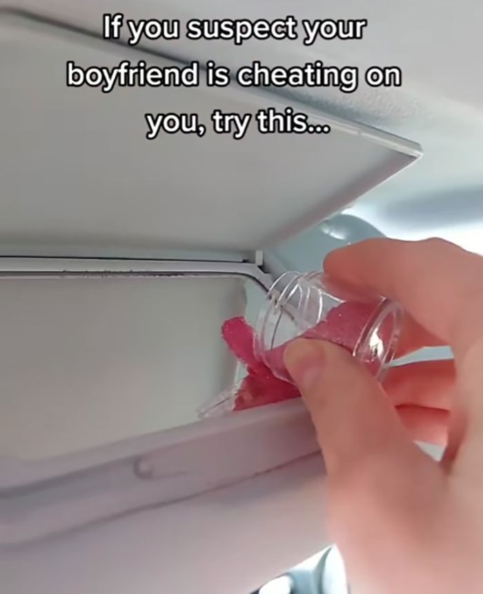 Hand pouring glitter into a car's air conditioning vent as a prank related to destroying ex's car engine.