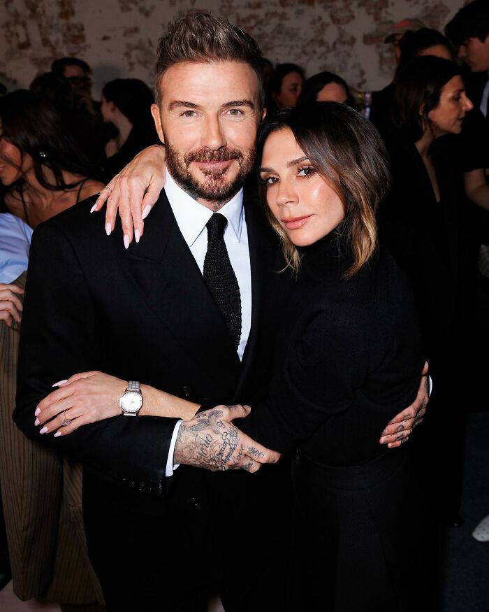 David and Victoria Beckham posing closely at an event, reflecting reactions to son Brooklyn's vow renewal speech.
