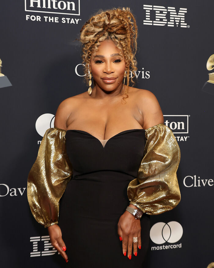 Serena Williams posing at an event, wearing a black dress with gold sleeves, highlighting her dramatic transformation and weight loss.