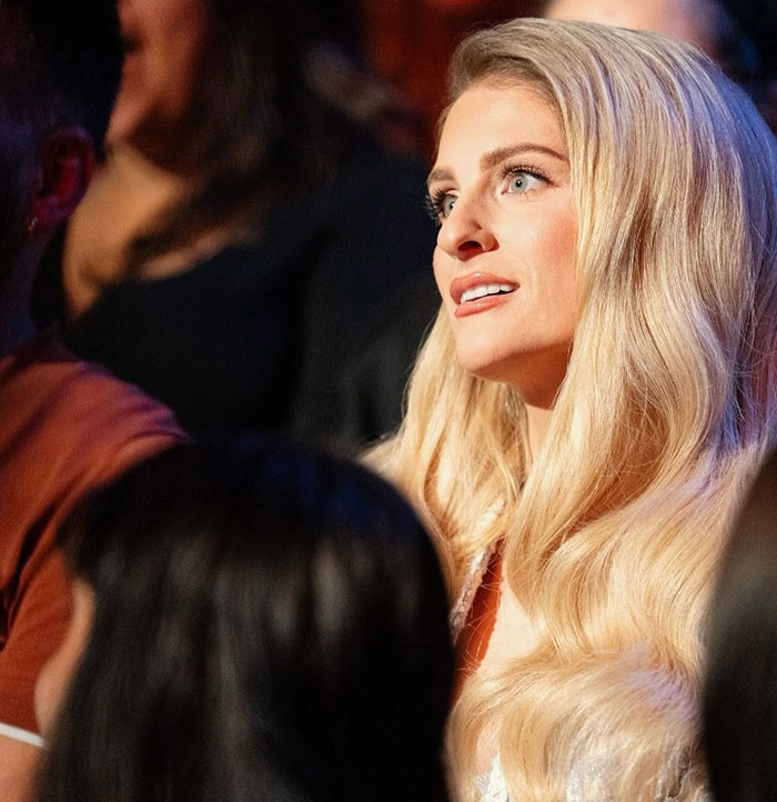 Meghan Trainor with long blonde hair and glowing makeup, appearing unrecognizable and stunning fans in new video.