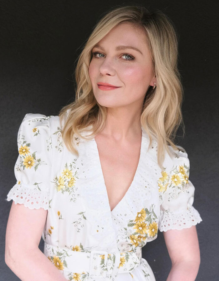 Kirsten Dunst posing in a floral white dress with yellow flowers, revealing the real pronunciation of her name. Kirsten Dunst posing in a floral white dress with yellow flowers, revealing the real pronunciation of her name.