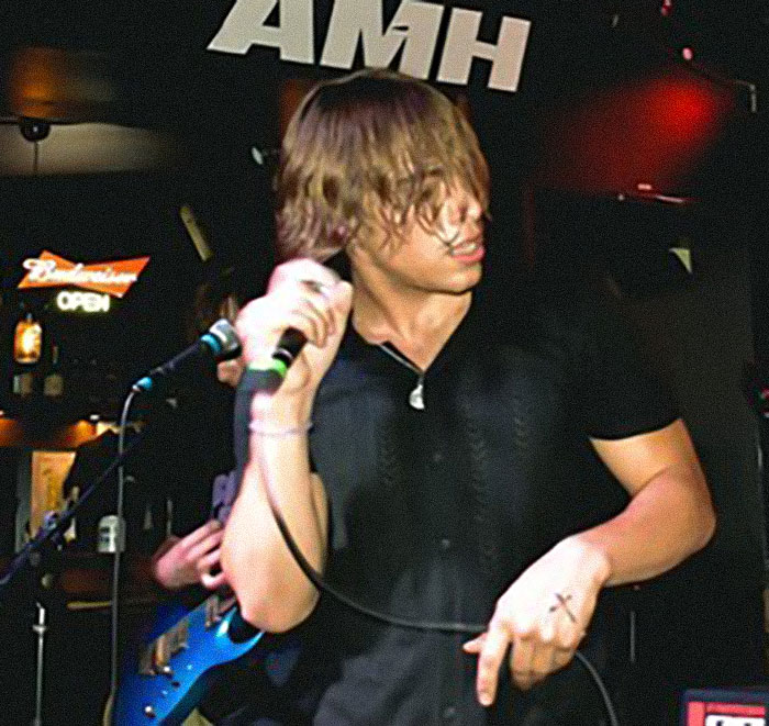 Young male singer performing on stage with microphone, representing Chase Filandro&rsquo;s story at 20 years old.