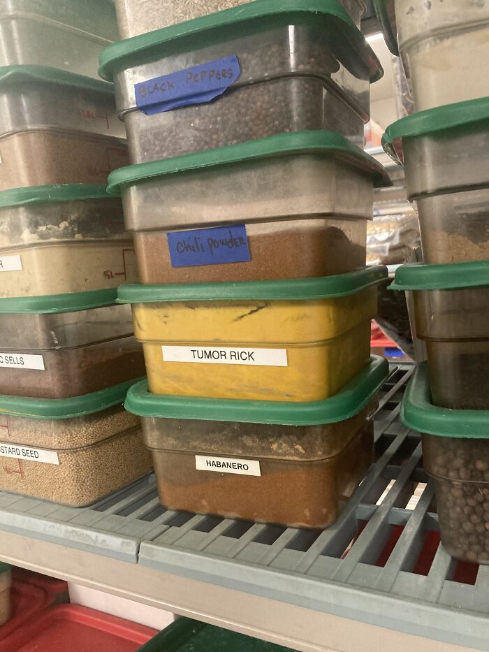 Stacked containers of spices including a mislabeled one showing a funny typo, highlighting typos that question intelligence.