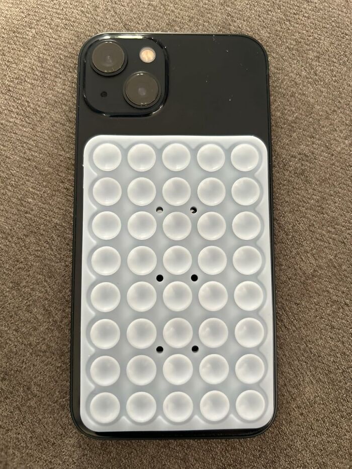 Black smartphone with a white pop-it fidget phone case accessory, one of the most add to cart worthy finds trending on Amazon.