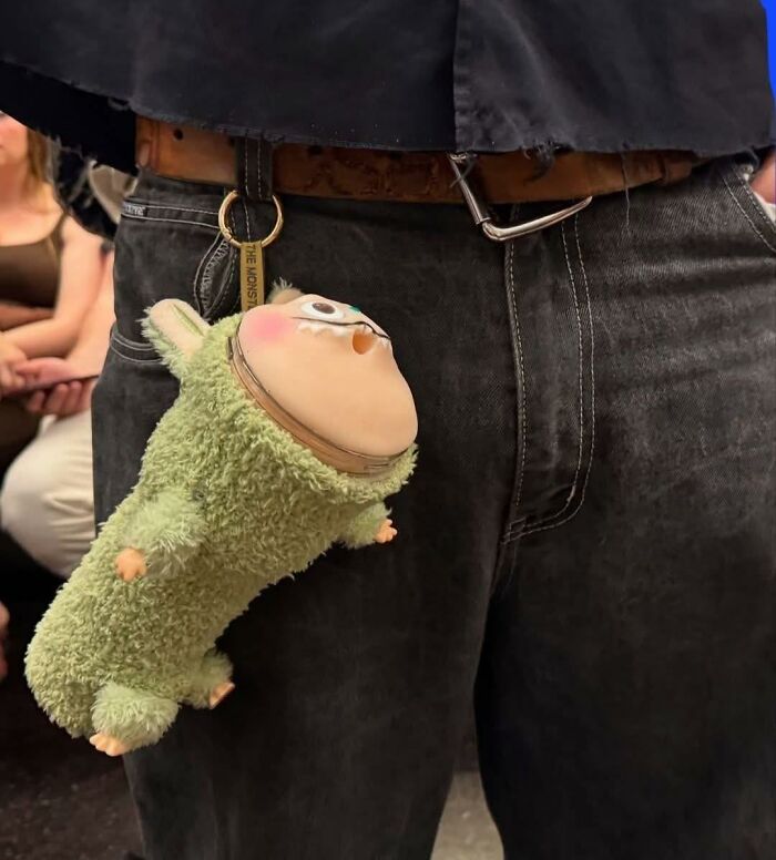 Plush toy with distorted face hanging as a keychain from belt loop, a funny example of horrendous DIY craft shaming projects.