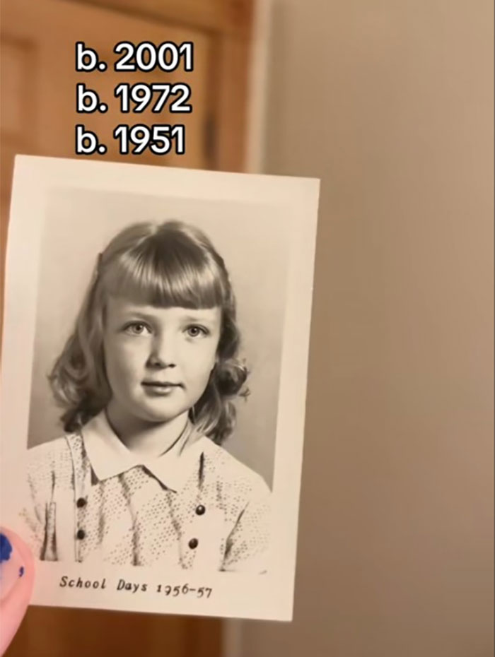Vintage black and white school photo held by hand with birth years, illustrating family historian sharing family tree online.
