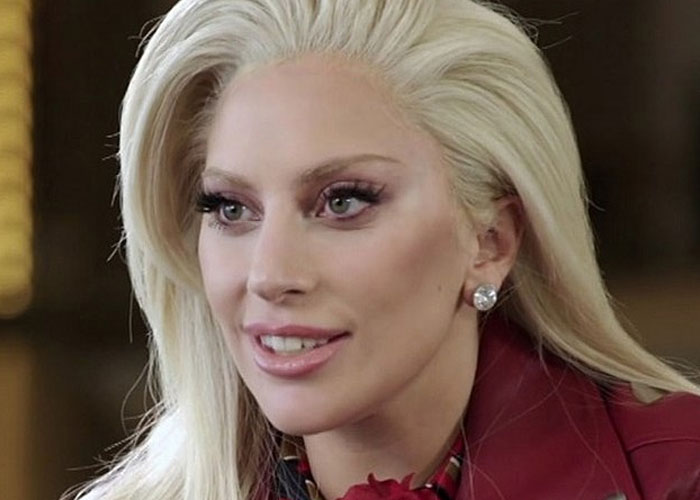 Close-up of a blonde celebrity with makeup and earrings, sharing a story about running into celebrities and wild experiences.