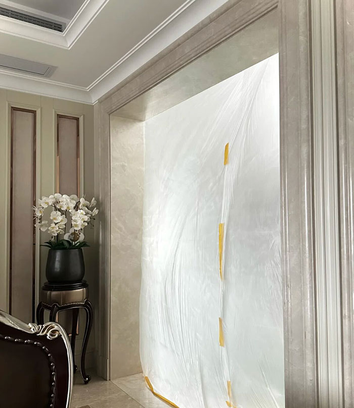 Luxurious interior with expensive glass ceiling and chandelier area covered by protective plastic wrap.