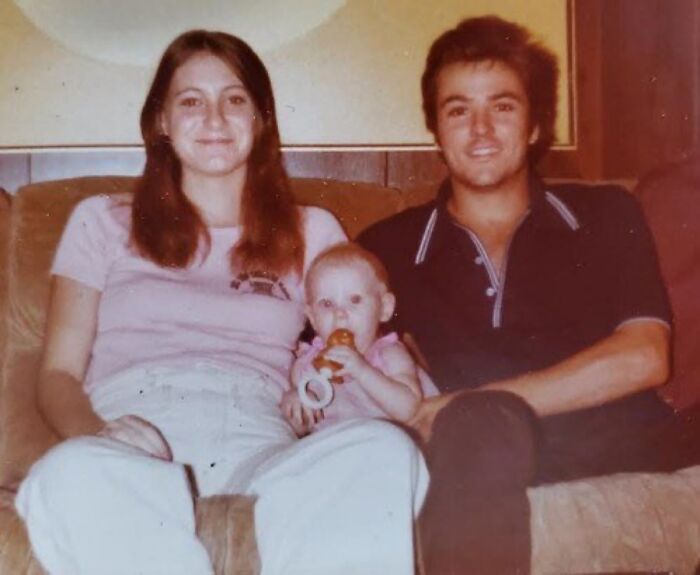 Vintage family photo with a mother, father, and baby on a couch, evoking unsettling images from Morbid Knowledge group.