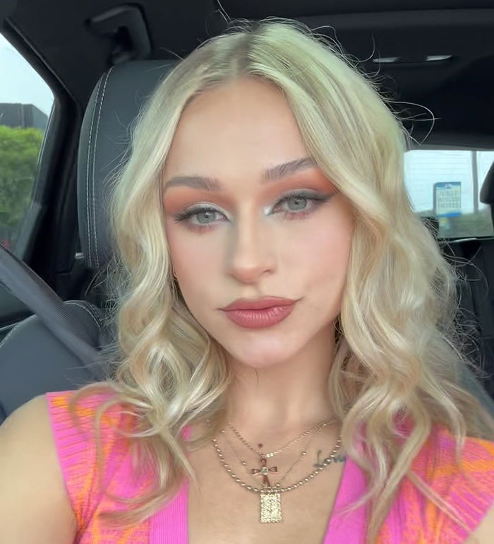 23-year-old woman with blonde hair and makeup, sitting in a car after quitting a $180k job over gross comments from men