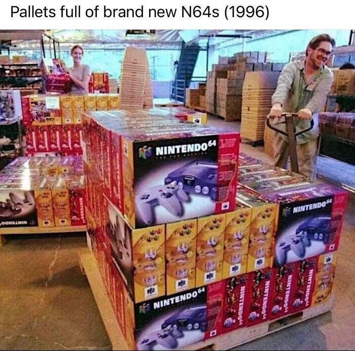 Pallets stacked with brand new Nintendo 64 consoles in a warehouse, evoking ‘90s nostalgia club memories.