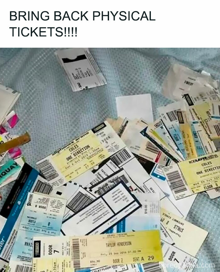 A collection of nostalgic physical concert and event tickets scattered on a blue fabric surface.
